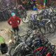 Interior of Bikes and Beans in Fishtown with a man standing in the middle of a lot of bicycles.